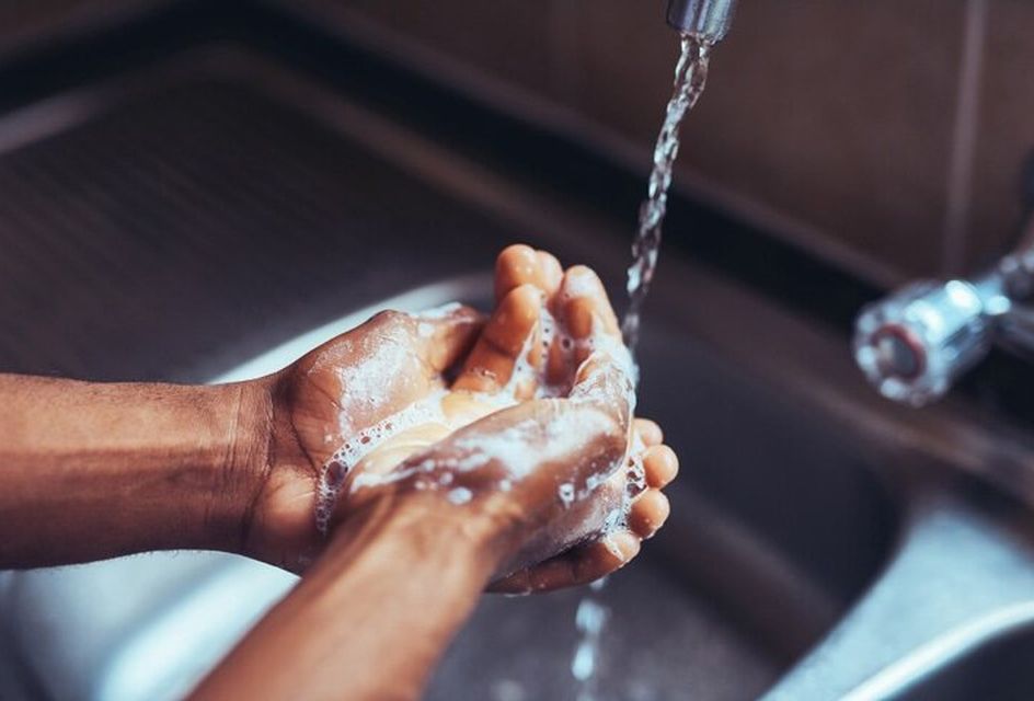 Someone washing their hands under a tap with soap