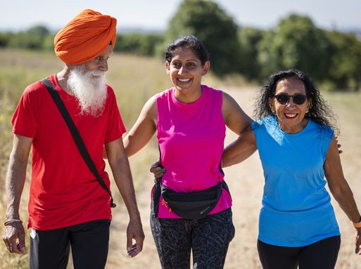A group of two women and a man take a walk in the park.