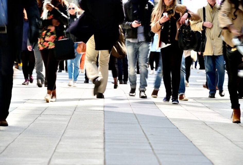 A crowd of people walking down a busy street.
