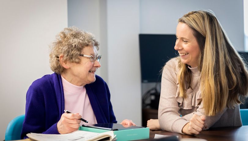 A healthcare worker speaking to an older woman