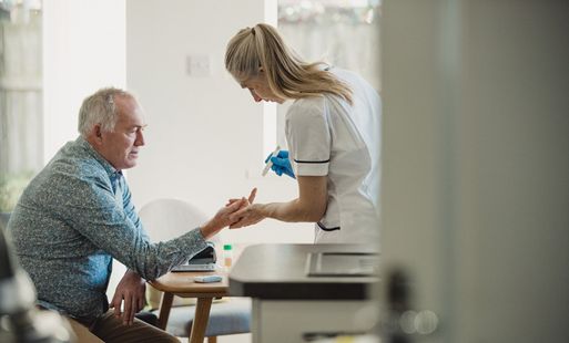 A healthcare worker treating an older man