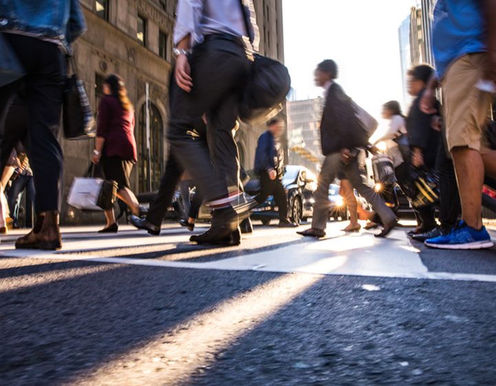 A crowd of people walking across a city street