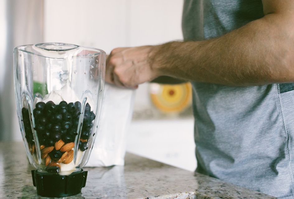 A man making a smoothie as part of a sports nutrition regime