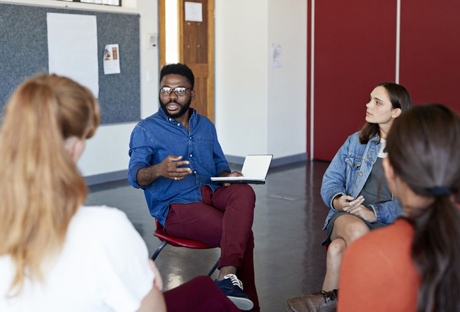 A group of people sat in a circle talking.