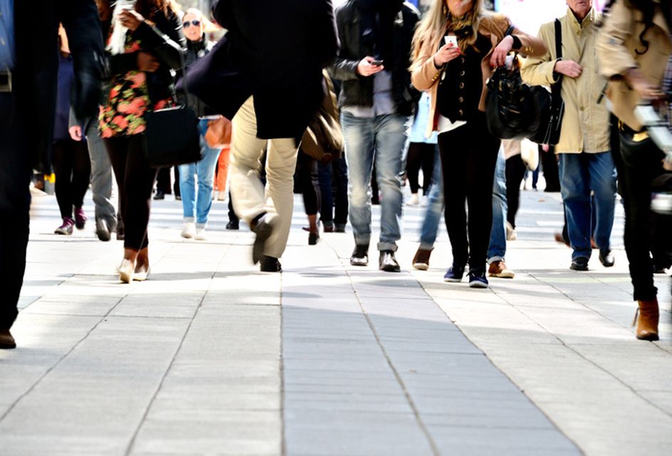 Crowd of people walking along a busy street