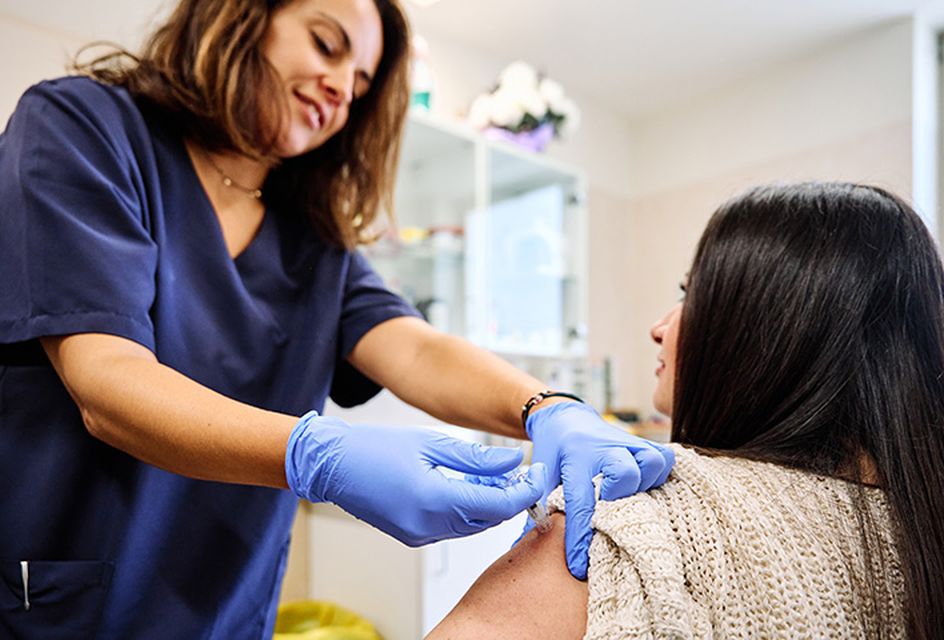 A nurse providing a vaccine to a female patient