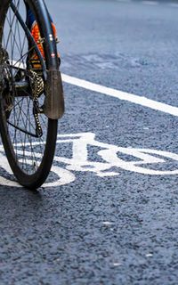 A close-up of a bike being ridden along a cycle lane.