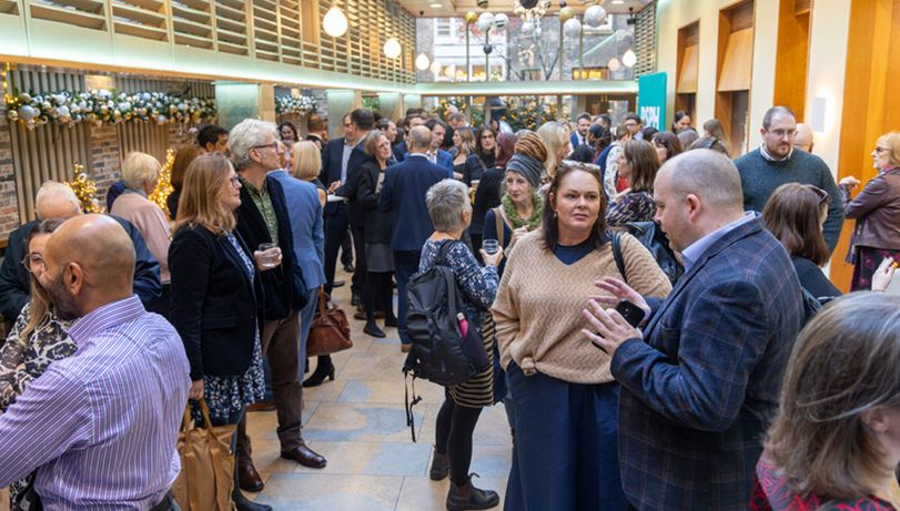 Room full of standing people engaged in conversation at the Health & Wellbeing awards ceremony