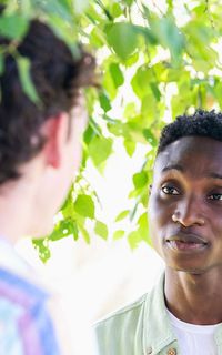 Two men talking under a tree