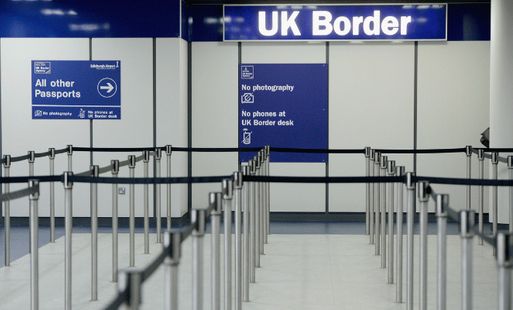 The entrance to UK border control, with a sign reading "UK Border" and barriers set up for queuing.