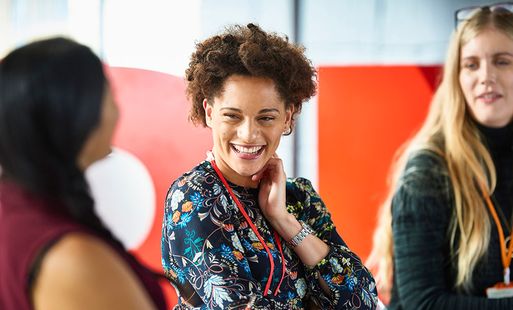 A woman in a professional setting is talking with her colleagues.