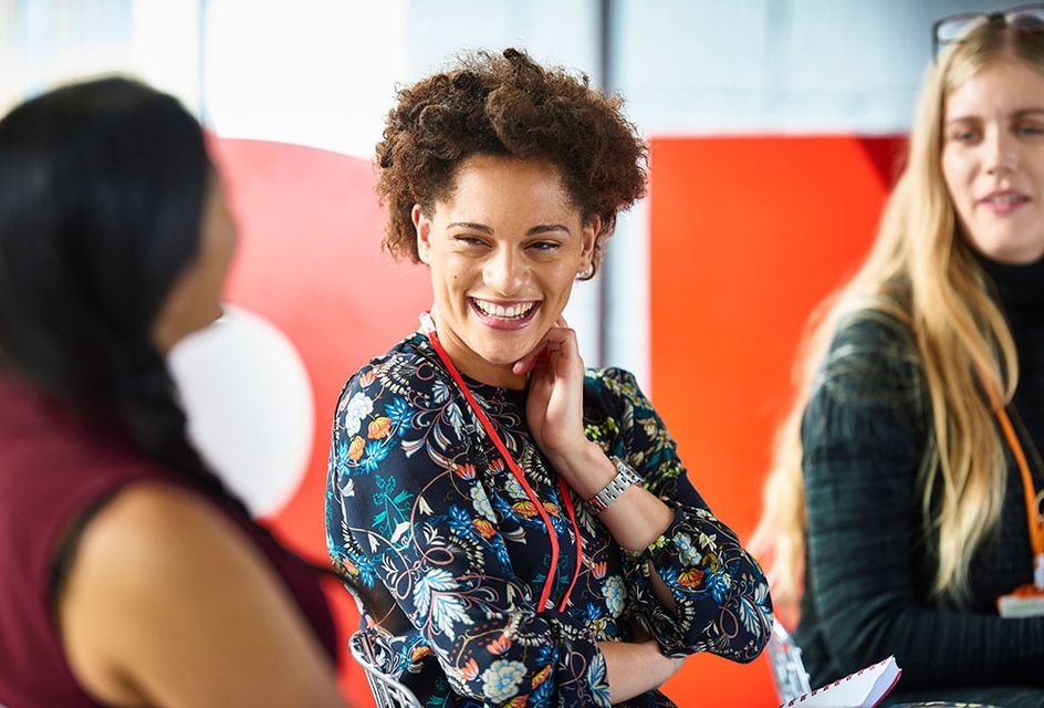 A woman in a professional setting is talking with her colleagues.